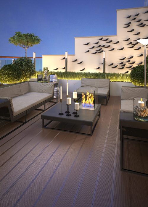 Espace extérieur moderne avec canapé, table basse, bougies, et cheminée à ethanol, illuminé par des lumières douces et décoré de plantes, représentant un projet d'aménagement extérieur clé en main par Patio Exotic.