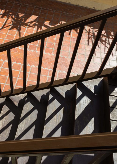 Rampe de patio en bois avec ombres sur des marches, soulignant la sécurité et le design pour un espace extérieur esthétique.